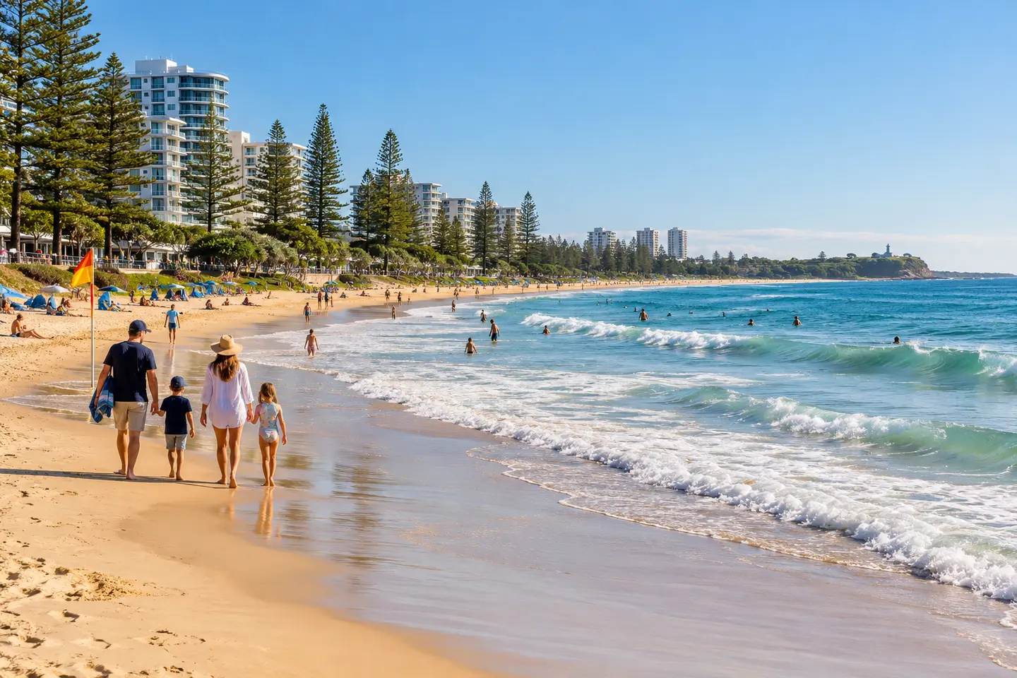 A family walking beside the clear water at Mooloolaba Beach